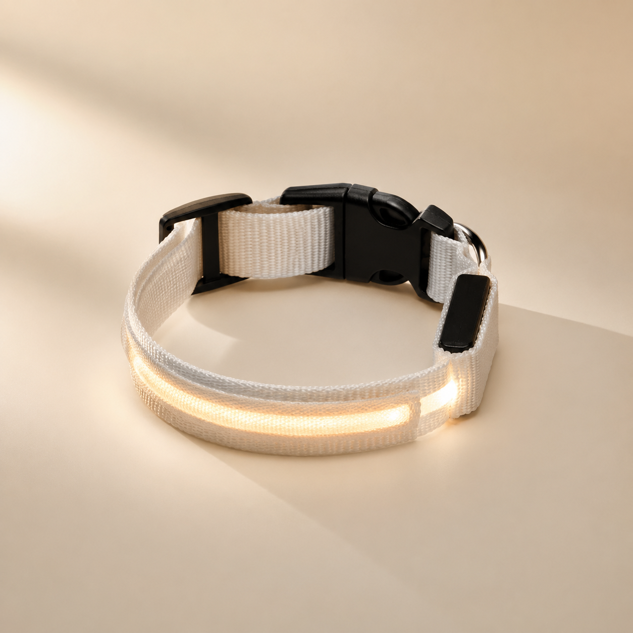 Close-up of a USB rechargeable LED dog collar with a warm white glow on a neutral background